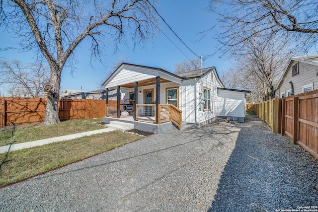 bungalow featuring covered porch and fence