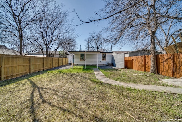 rear view of property with a yard and a fenced backyard