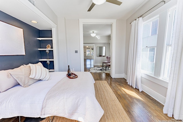 bedroom with baseboards, wood finished floors, and a ceiling fan