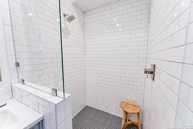 bathroom with vanity and a tile shower