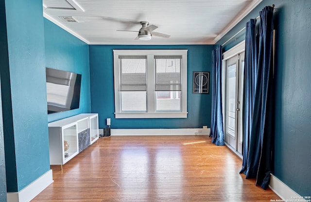 interior space featuring a ceiling fan, crown molding, wood finished floors, and visible vents