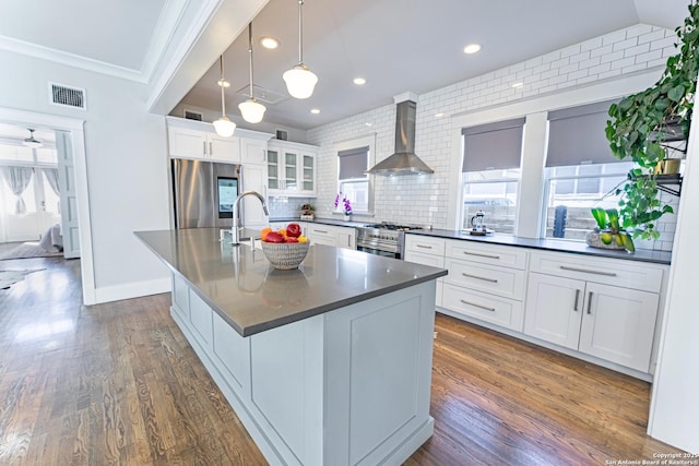 kitchen with dark countertops, visible vents, tasteful backsplash, stainless steel appliances, and wall chimney exhaust hood