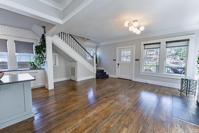 entrance foyer with stairs, crown molding, dark wood finished floors, and baseboards