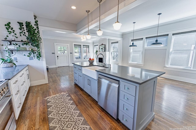 kitchen with a sink, dark countertops, dark wood-style floors, range, and dishwasher