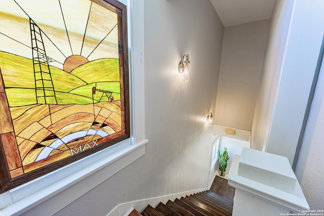 stairway featuring baseboards and wood finished floors