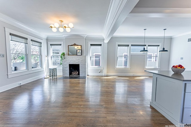 unfurnished living room featuring a healthy amount of sunlight, crown molding, and dark wood-style flooring