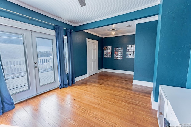 entryway with wood-type flooring, a wealth of natural light, and ornamental molding