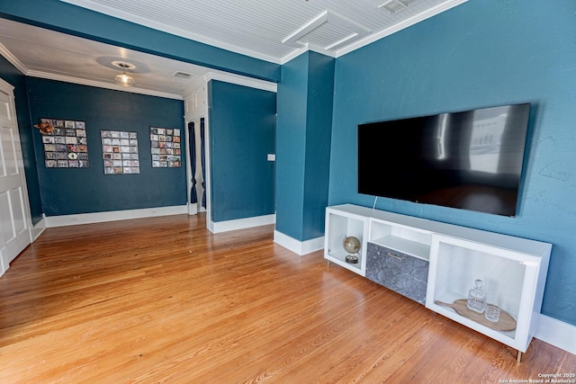 unfurnished living room with visible vents, crown molding, baseboards, and wood finished floors