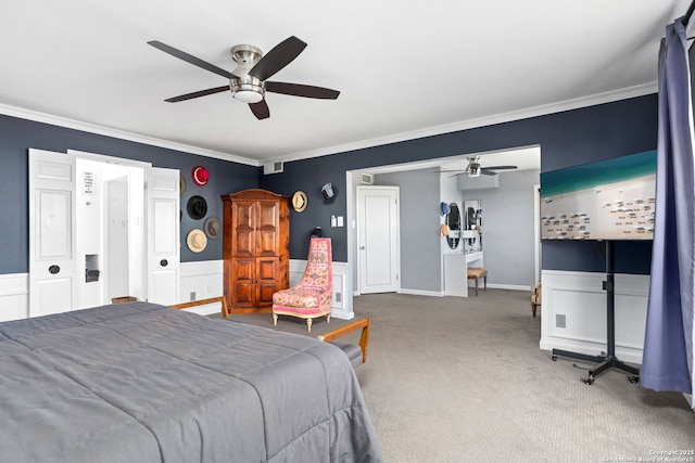 carpeted bedroom featuring ceiling fan, ornamental molding, and wainscoting