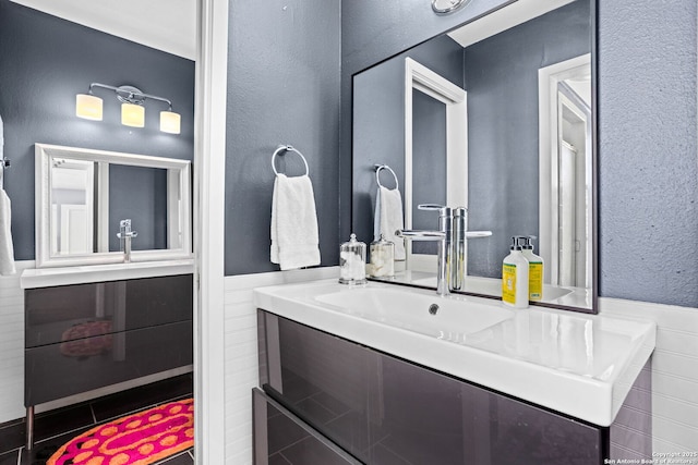 bathroom with a wainscoted wall and vanity