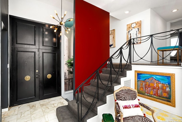 foyer with recessed lighting, stairway, marble finish floor, and a chandelier