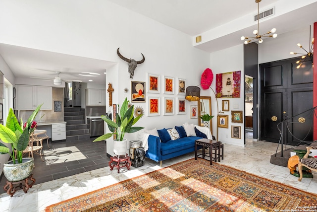 living area with visible vents, stairway, a towering ceiling, a notable chandelier, and marble finish floor