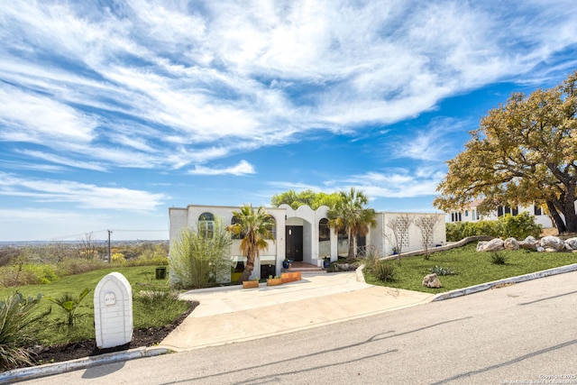 view of front of home with stucco siding and a front yard