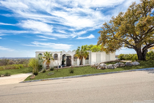 view of front of home with a front lawn, concrete driveway, and stucco siding