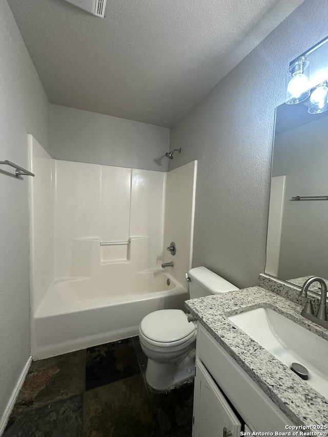 bathroom with a textured ceiling, bathtub / shower combination, vanity, and toilet