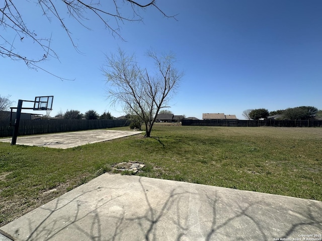 view of yard with community basketball court and fence