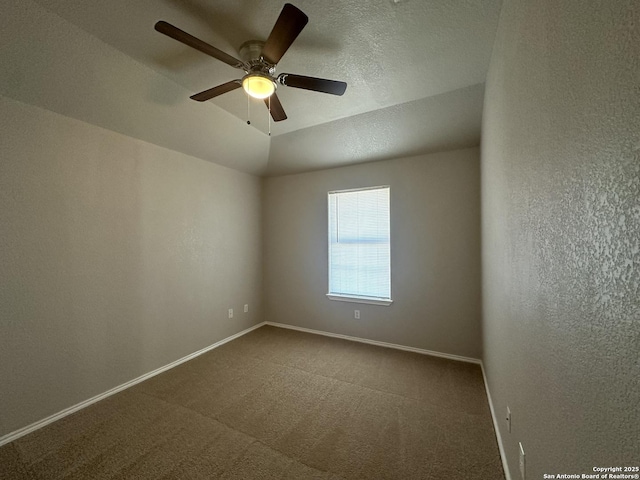 unfurnished room featuring a ceiling fan, a textured ceiling, dark carpet, baseboards, and a textured wall