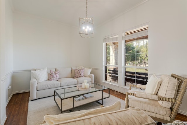 living room featuring ornamental molding, wood finished floors, baseboards, and a chandelier