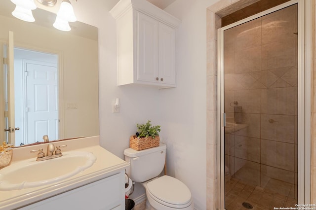 bathroom with vanity, a shower stall, and toilet