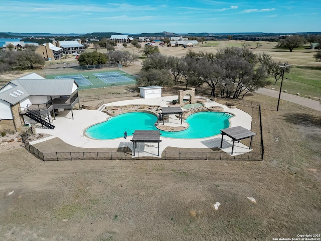 community pool with a patio area and fence