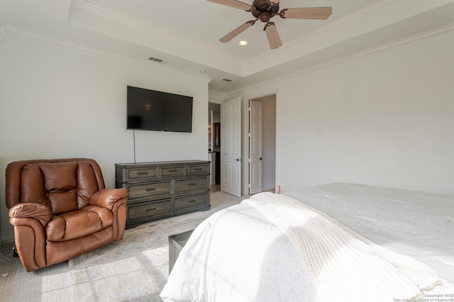 bedroom featuring a tray ceiling, light colored carpet, visible vents, and ornamental molding