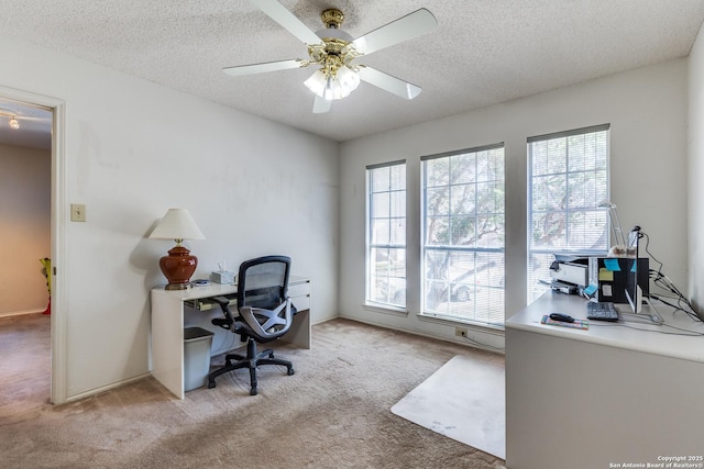 carpeted home office featuring a textured ceiling and ceiling fan