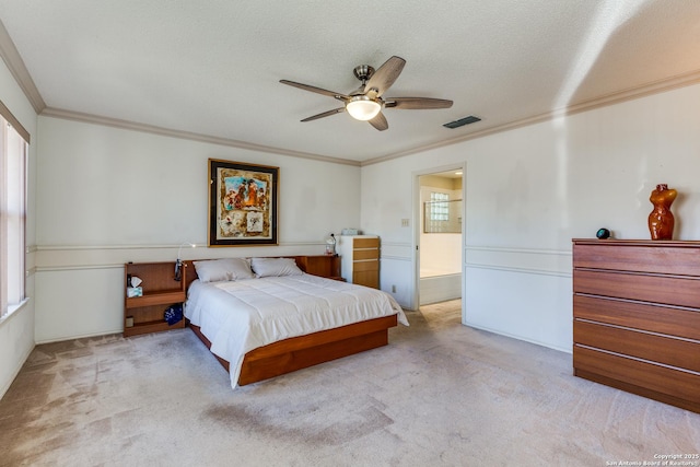 bedroom with visible vents, a textured ceiling, carpet floors, crown molding, and ceiling fan