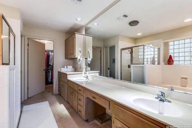 bathroom featuring a sink, visible vents, a stall shower, and double vanity