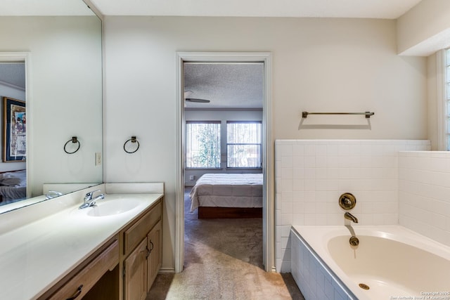 ensuite bathroom featuring connected bathroom, a textured ceiling, vanity, and a garden tub