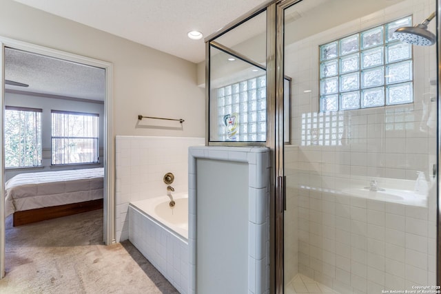 ensuite bathroom featuring a bath, a stall shower, a textured ceiling, and ensuite bathroom