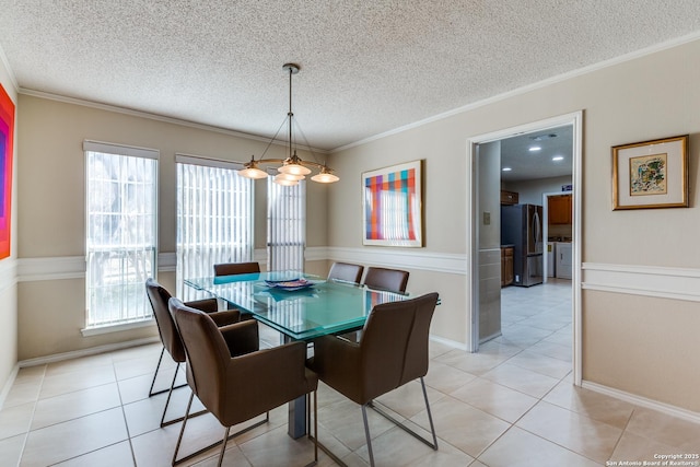 dining space featuring light tile patterned floors, a textured ceiling, and crown molding