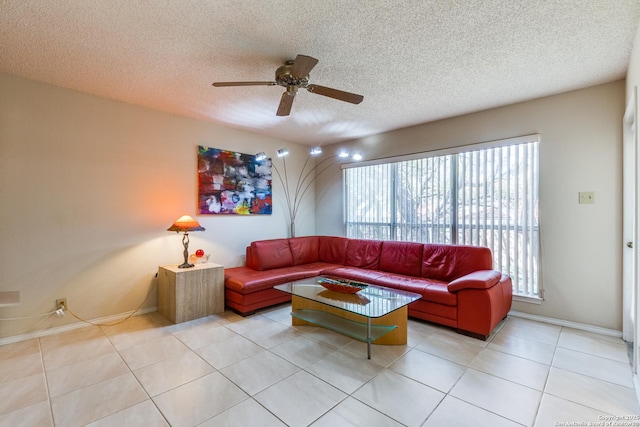 living room with light tile patterned floors, baseboards, a textured ceiling, and a ceiling fan