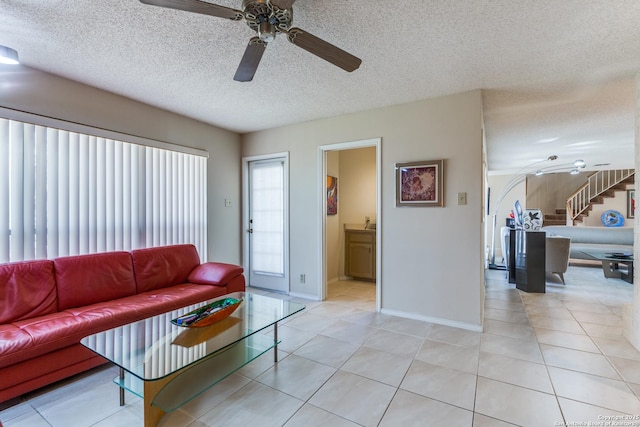 living room with stairway, a textured ceiling, ceiling fan, and light tile patterned flooring