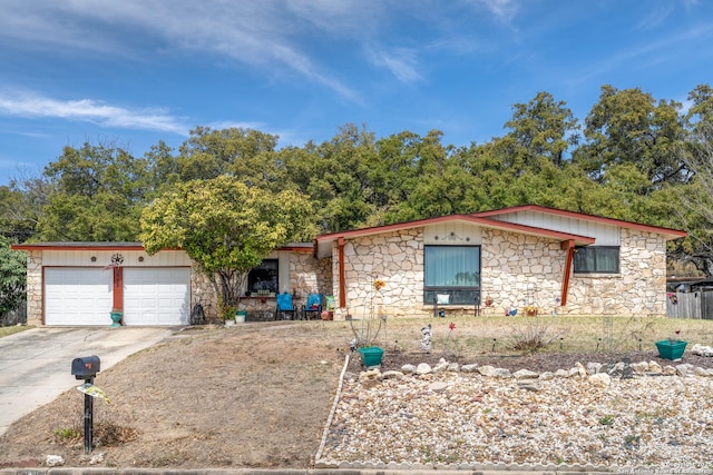 view of front of house with stone siding, driveway, and an attached garage