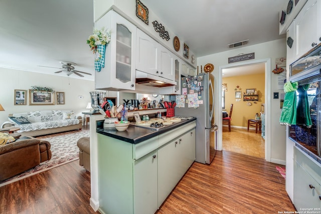 kitchen featuring wood finished floors, visible vents, a ceiling fan, glass insert cabinets, and white cabinetry