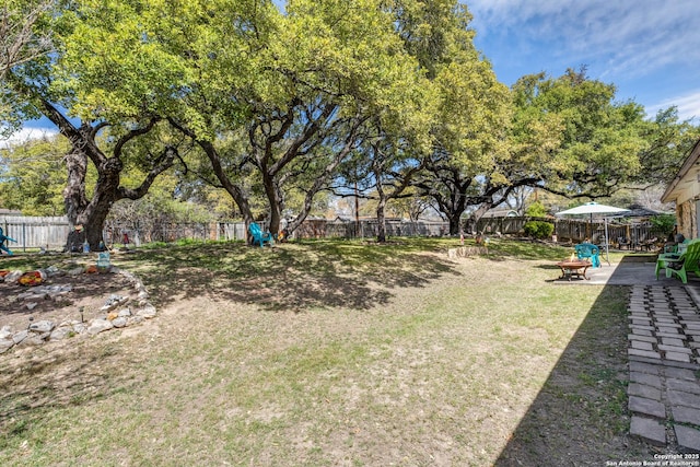 view of yard featuring a patio, a fire pit, and a fenced backyard