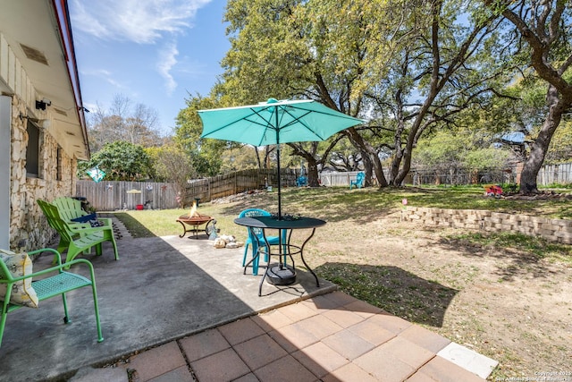 view of patio featuring a fenced backyard and an outdoor fire pit