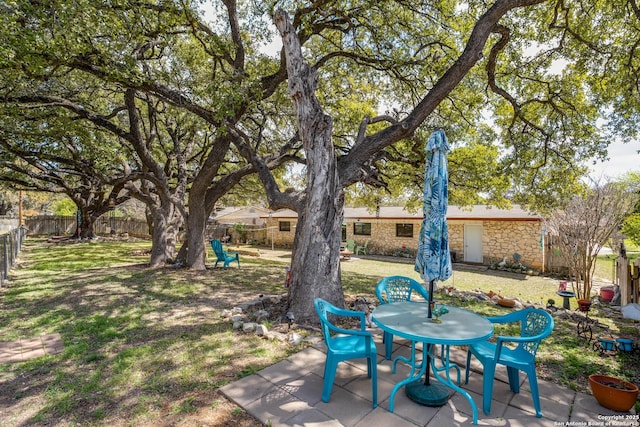 view of yard featuring outdoor dining space, a patio area, and a fenced backyard