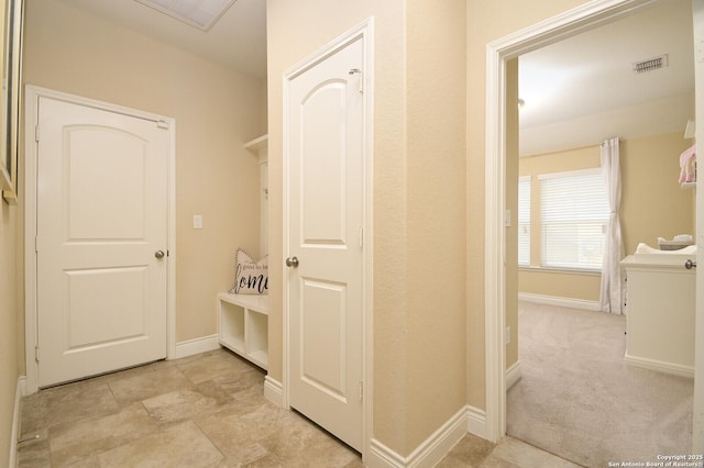 hall featuring visible vents and baseboards