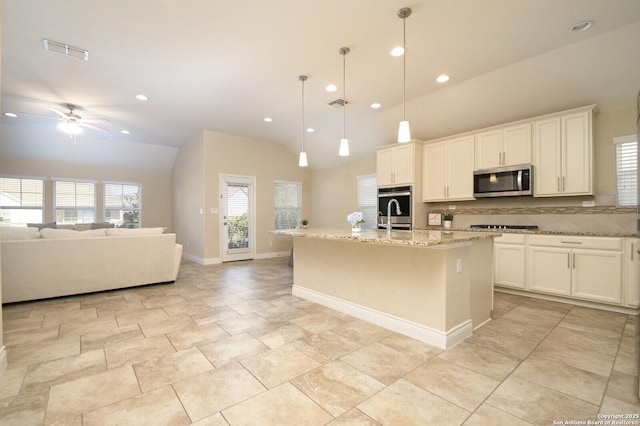 kitchen featuring open floor plan, light stone countertops, visible vents, and stainless steel appliances