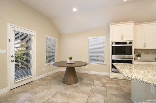 dining space featuring recessed lighting, baseboards, and lofted ceiling