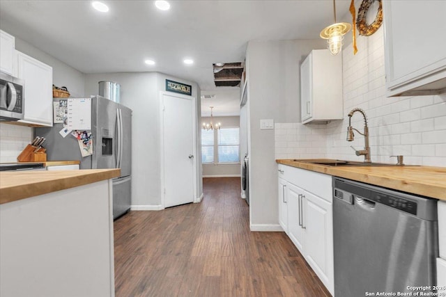 kitchen with a sink, wooden counters, dark wood-type flooring, and appliances with stainless steel finishes