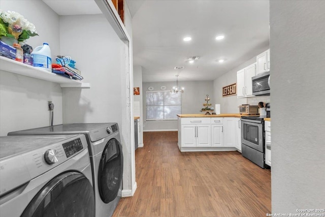 clothes washing area with visible vents, baseboards, dark wood finished floors, a notable chandelier, and separate washer and dryer