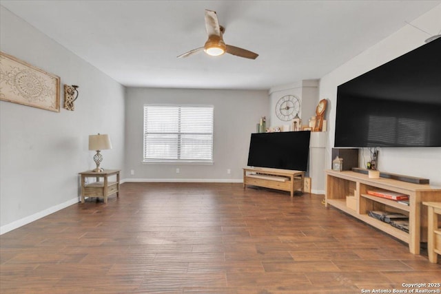 living room featuring wood finished floors, a ceiling fan, and baseboards