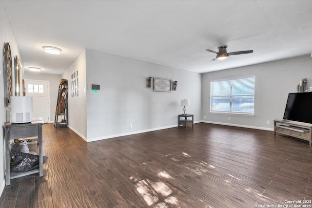 living room with baseboards, wood finished floors, and a ceiling fan