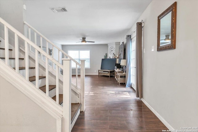 interior space featuring a ceiling fan, wood finished floors, visible vents, and baseboards