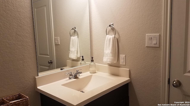 bathroom featuring vanity and a textured wall