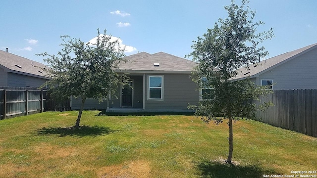 back of property featuring a lawn and a fenced backyard