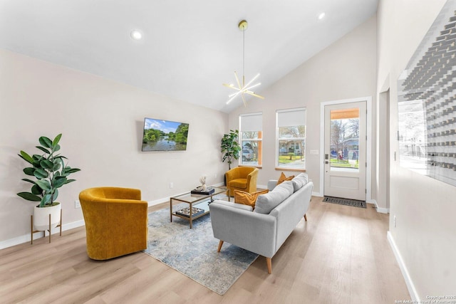 living room with light wood-type flooring, high vaulted ceiling, recessed lighting, baseboards, and a chandelier