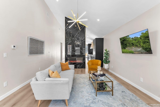 living room featuring baseboards, high vaulted ceiling, and wood finished floors